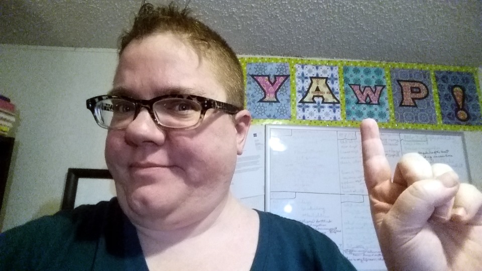 Me pointing at a banner I made with adult coloring book pages and wrapping paper. The banner says "YAWP!"